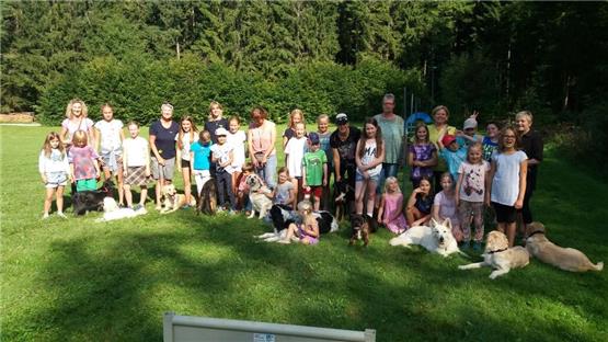 Ferienspielkinder gehen mit Hunden auf Schatzsuche